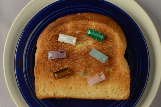 FREQNC atelier magnetic crystals for good luck and healing energy placed on toast. Featuring natural stones like Tiger Eye Amethyst Malachite Rose Quartz Amazonite and White Mother of Pearl to align your daily frequency.