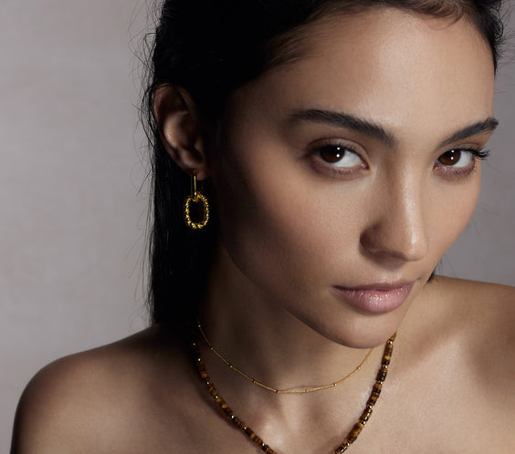 Rhea Gold Dot Necklace on model with layered necklaces - FREQNC