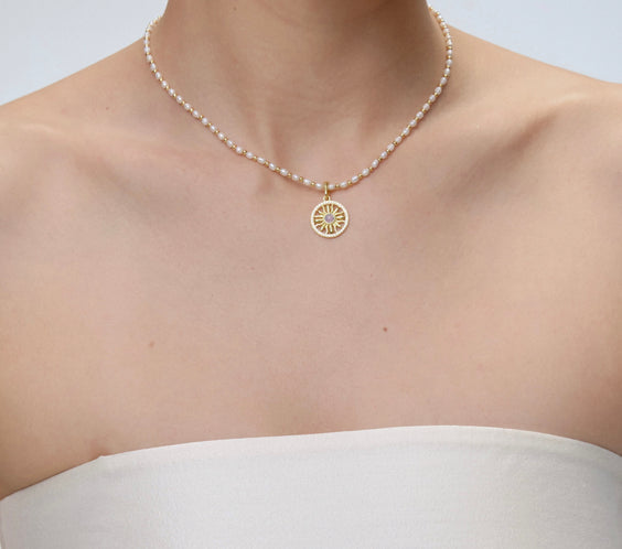 Sun Charm worn on model with gold chain necklace - FREQNC