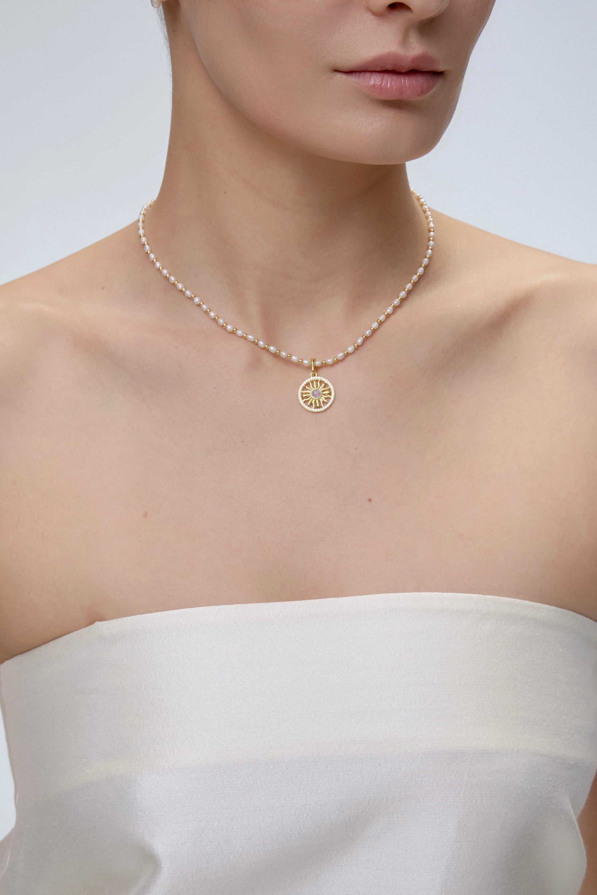 Sun Charm worn on model with gold chain necklace - FREQNC