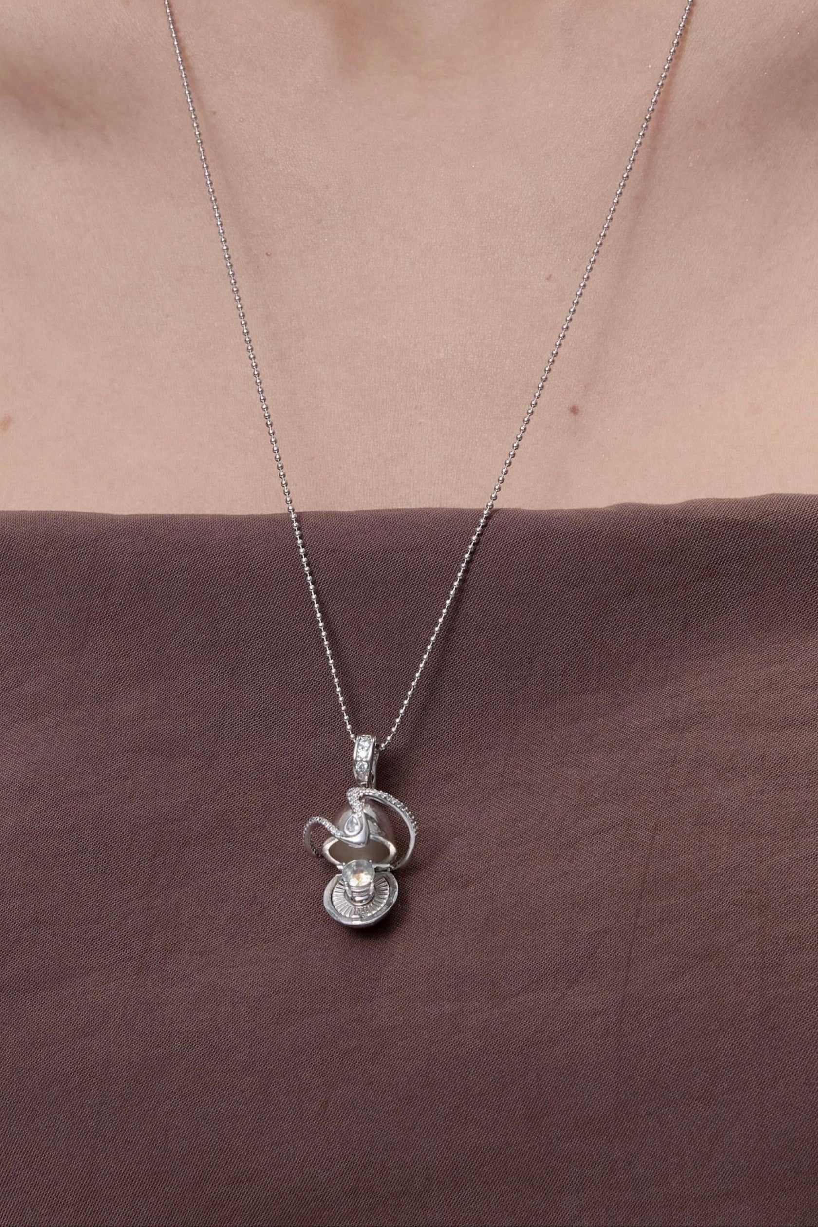 Orphic Egg Charm close-up detail of serpent and egg design - FREQNC atelier