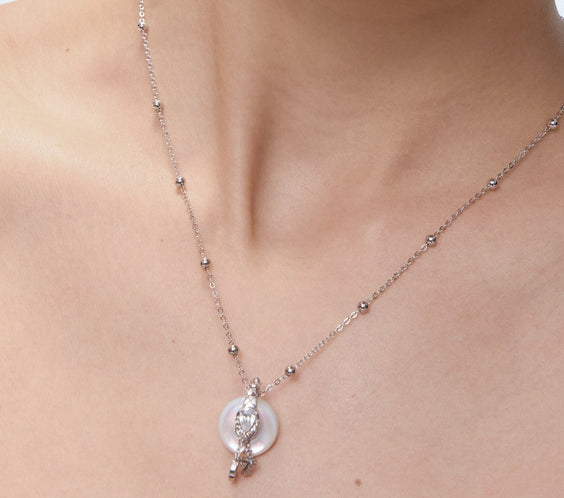 Ouroboros Charm worn on model with sun and moon charms - FREQNC