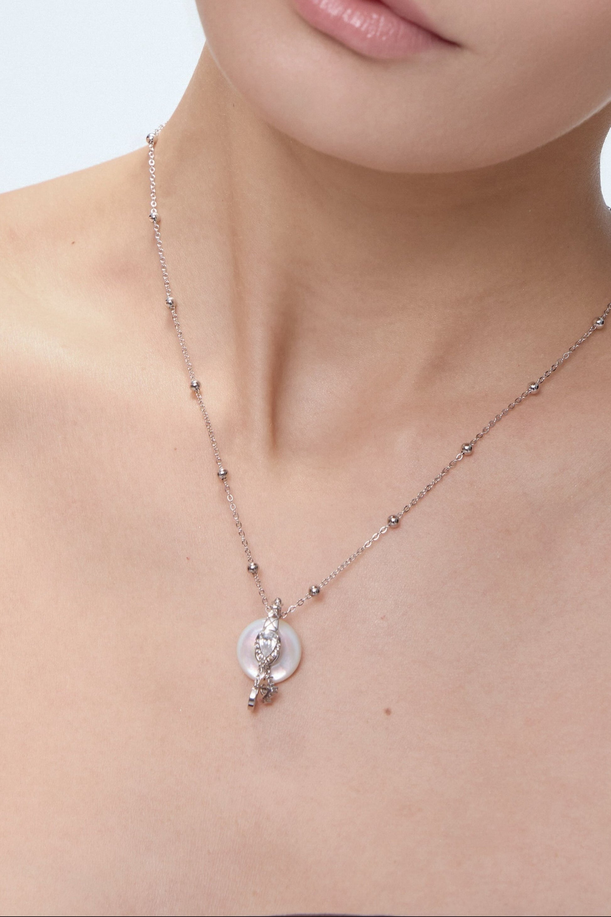 Ouroboros Charm worn on model with sun and moon charms - FREQNC