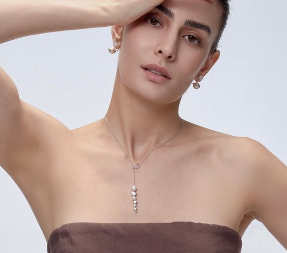 Orphic Cosmic Egg Earrings layered jewelry on model - FREQNC atelier