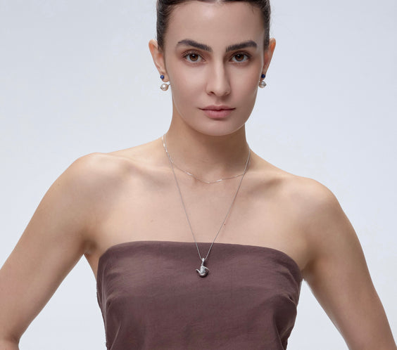 Orphic Egg Charm worn on model with gold chain necklace - FREQNC