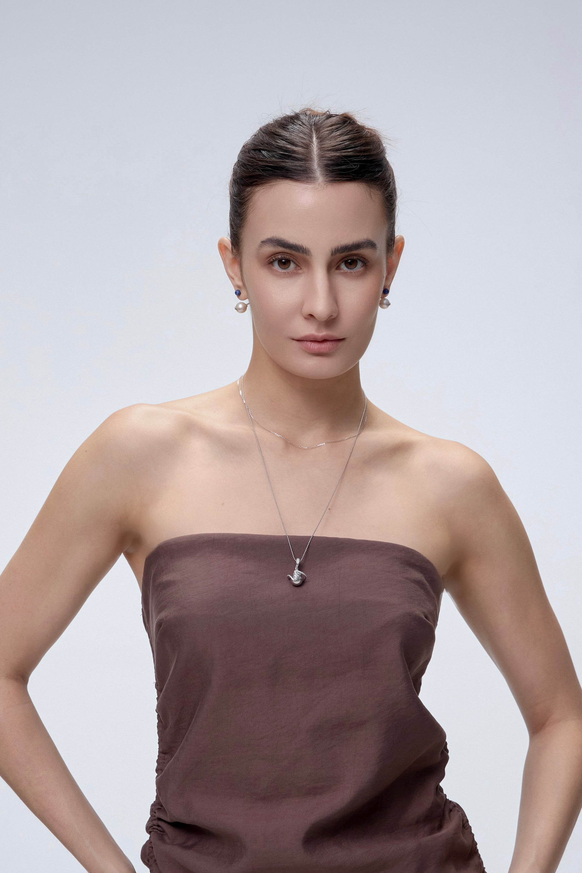 Orphic Egg Charm worn on model with gold chain necklace - FREQNC