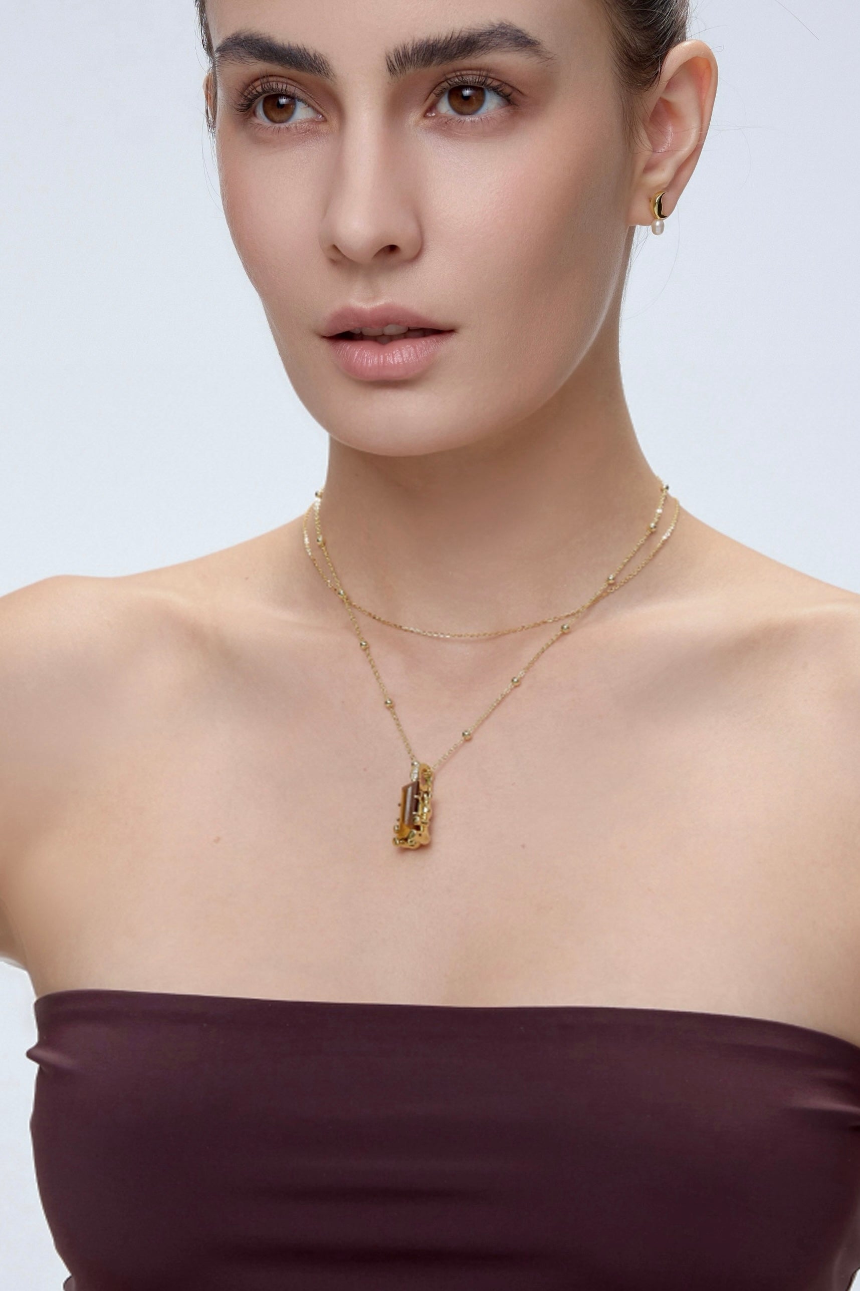 Cuddly Bear Charm with tiger's eye crystal worn on model with gold layered necklace - FREQNC magnetic pendant
